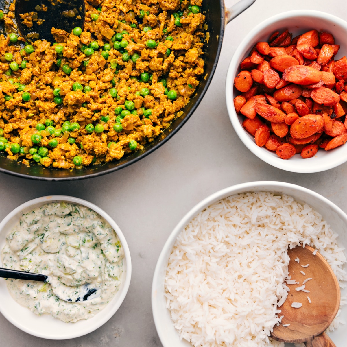 The Indian Ground Turkey in the pot, alongside roasted vegetables and rice, each in their own bowls, all ready to be combined to create a delicious and satisfying meal.