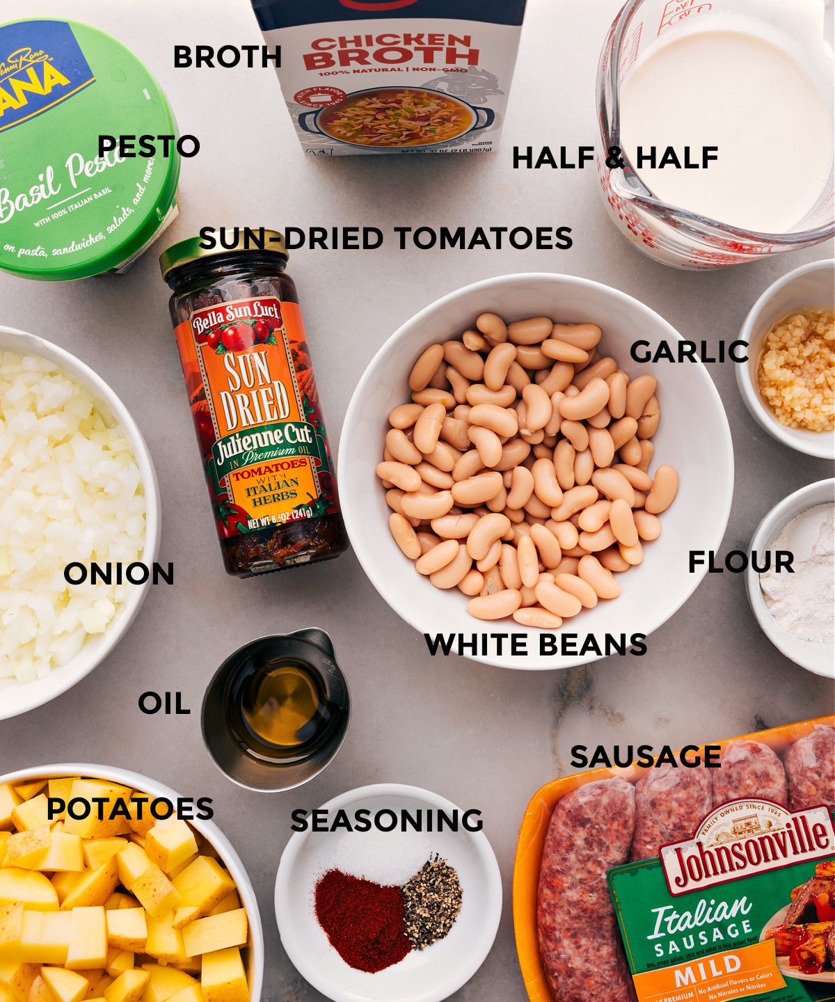 A collection of prepped ingredients for this recipe, including white beans, chopped onions, various seasonings, and more.