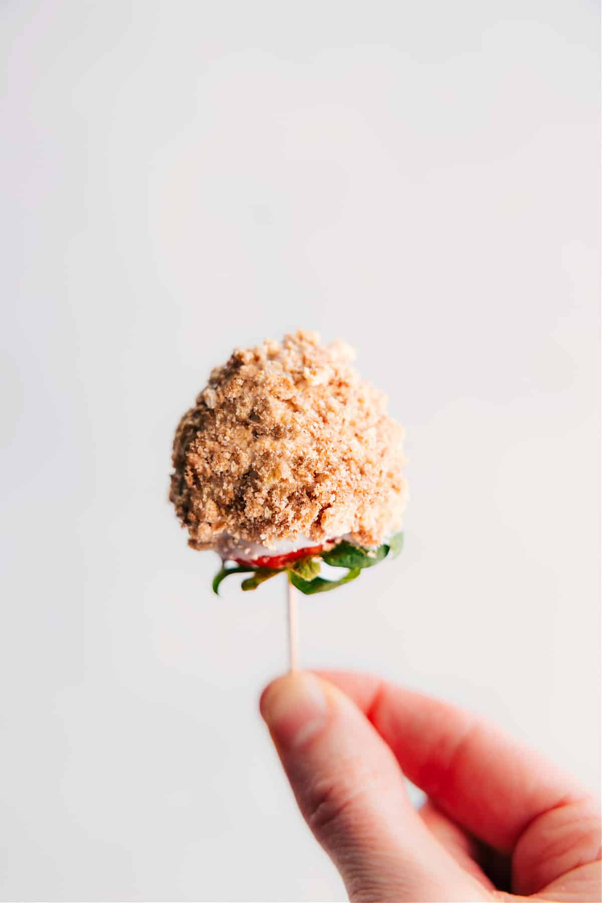 Closeup of a strawberry dipped in white chocolate and graham cracker crumbs
