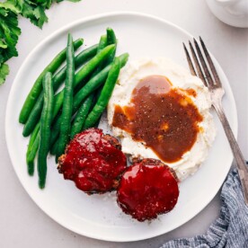 Mini Meatloaf Recipe on a plate with potatoes and green beans.