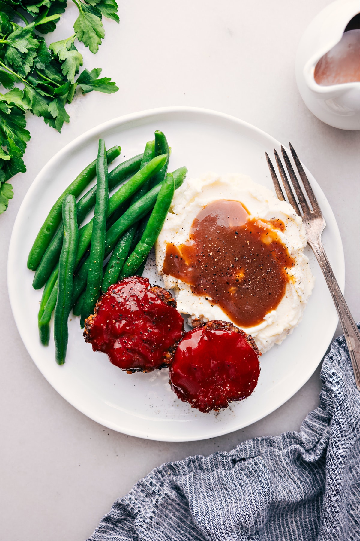 Mini Meatloaf Recipe on a plate with potatoes and green beans.