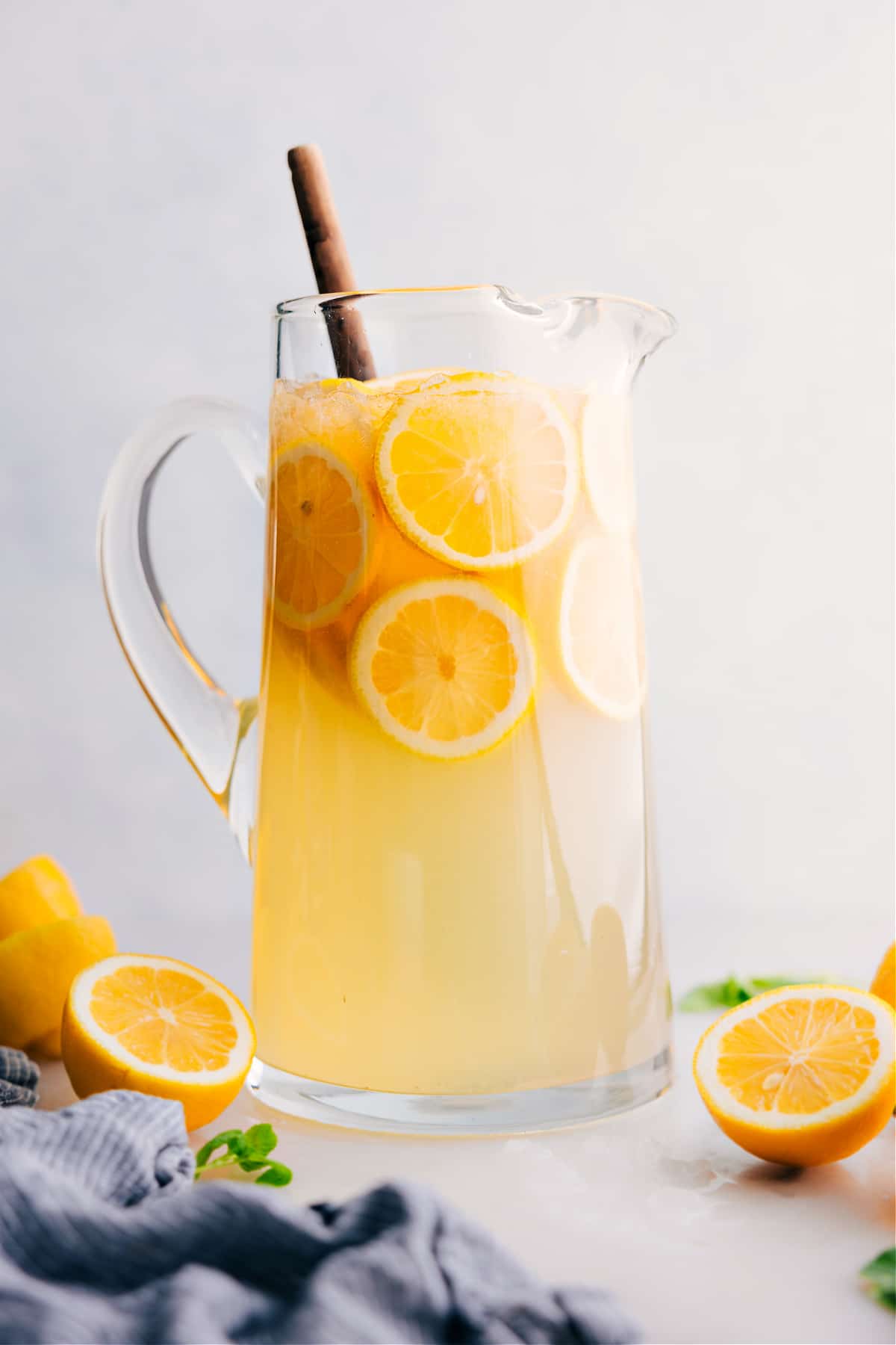 Lemonade recipe in a pitcher with fresh lemons.