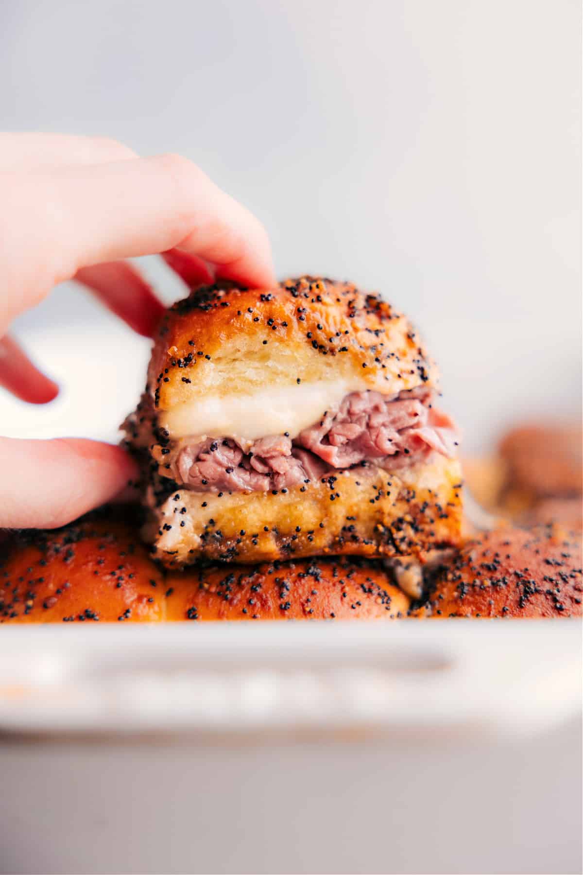 Roast Beef Sliders recipe fresh out of the with a hand picking one up.