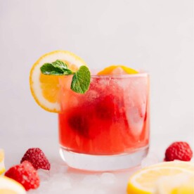 Raspberry Lemonade in a cup with garnishes.