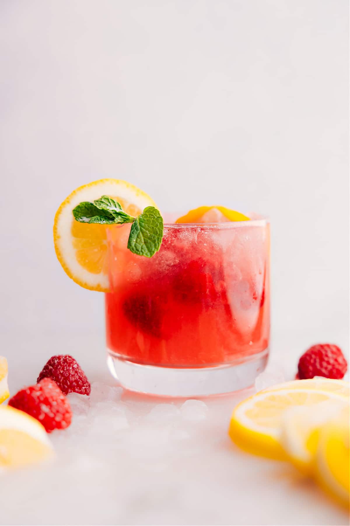 Sparkling Raspberry Lemonade in a cup with garnishes.