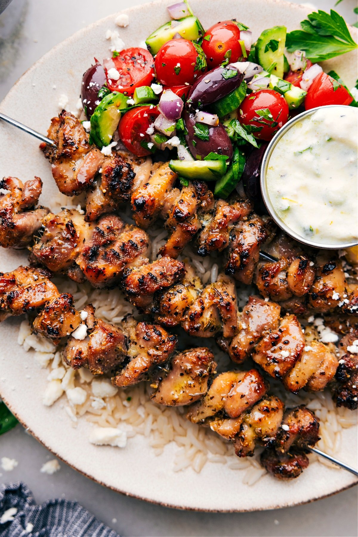 Greek Chicken Bowls assembled in a bowl with all the sides and toppings.