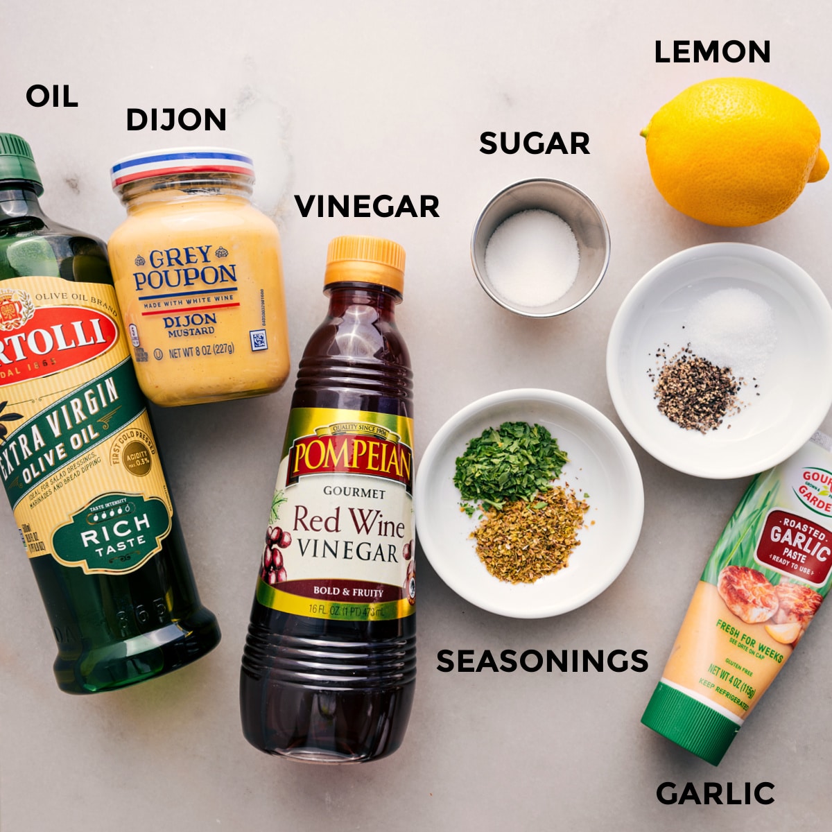 All the dressing ingredients for the dense bean salad are prepped and ready for easy assembly: oil, Dijon, vinegar, sugar, seasonings, garlic, and lemon.