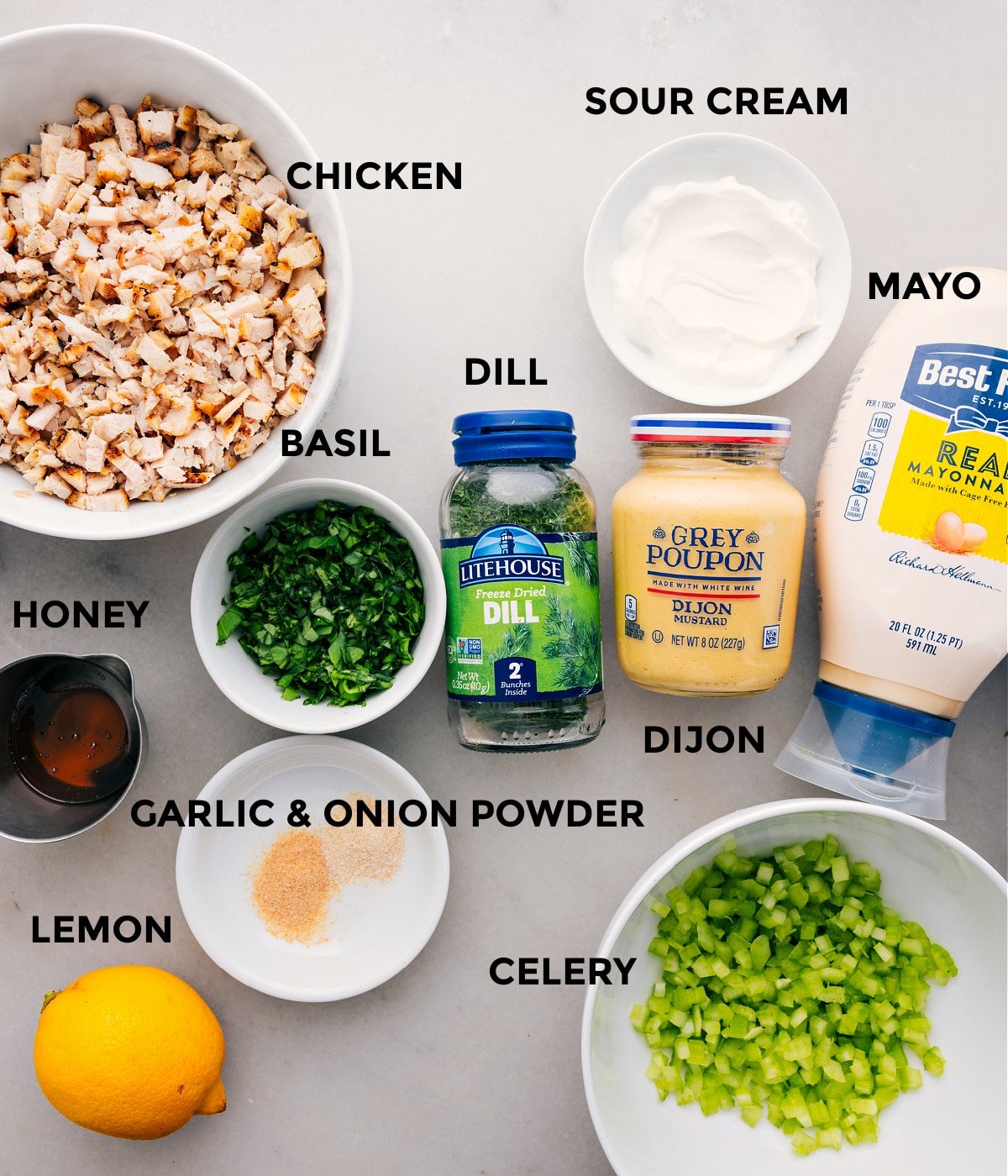 All the ingredients for this recipe are prepped and ready for easy assembly, including the meat, mayo, sour cream, dijon, herbs, celery, lemon, and honey.