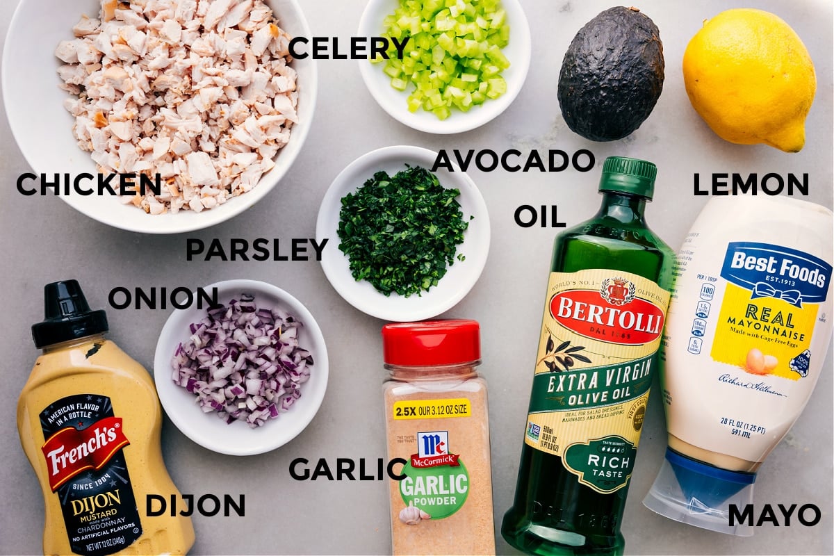 All the ingredients in this recipe prepped out for easy assembly including the meat, celery, avocado, parsley, onion, oil, lemon, mayo, garlic, and dijon.
