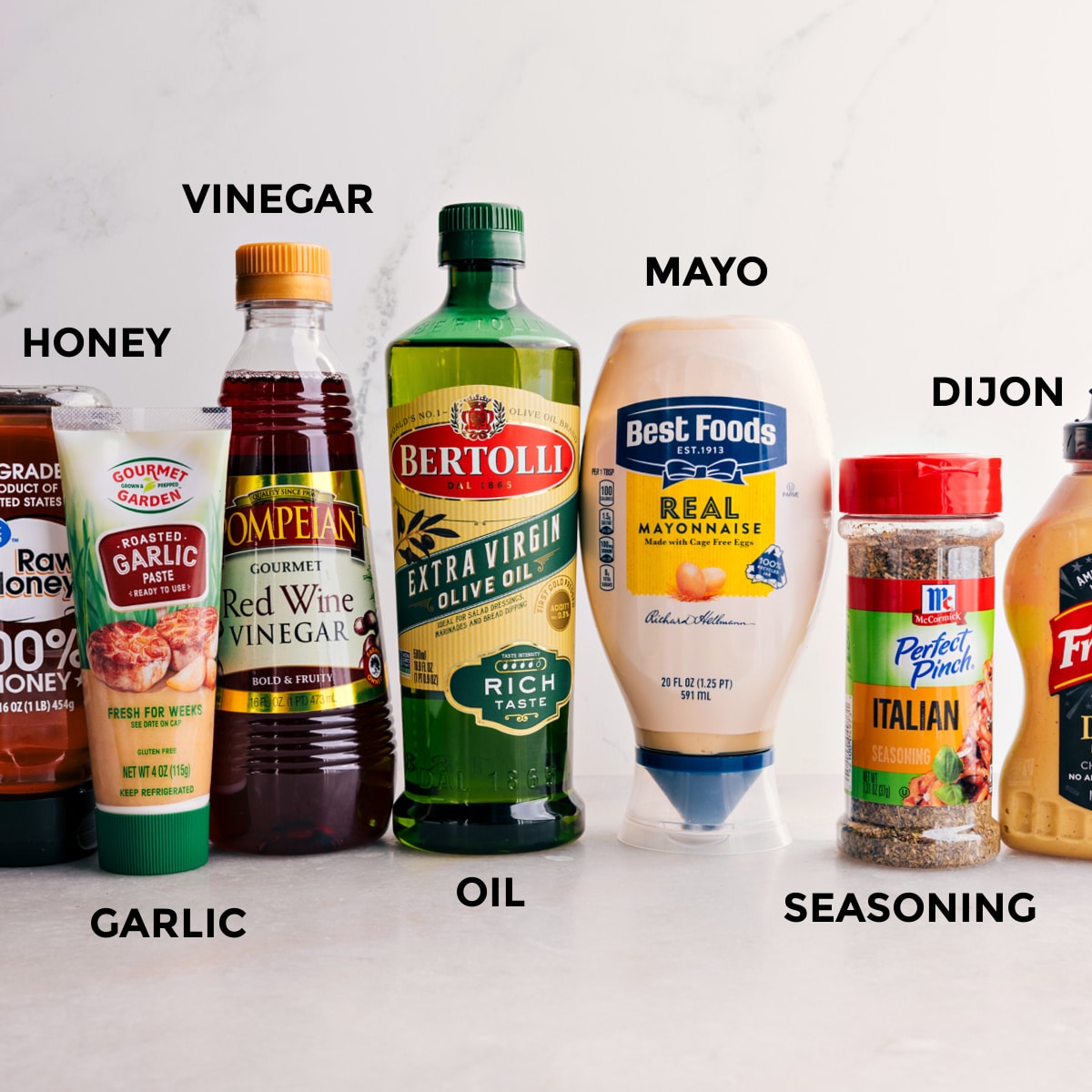All the dressing ingredients for this Italian Grinder Pasta Salad are prepped for easy mixing—honey, garlic, vinegar, oil, mayo, seasoning, and Dijon.