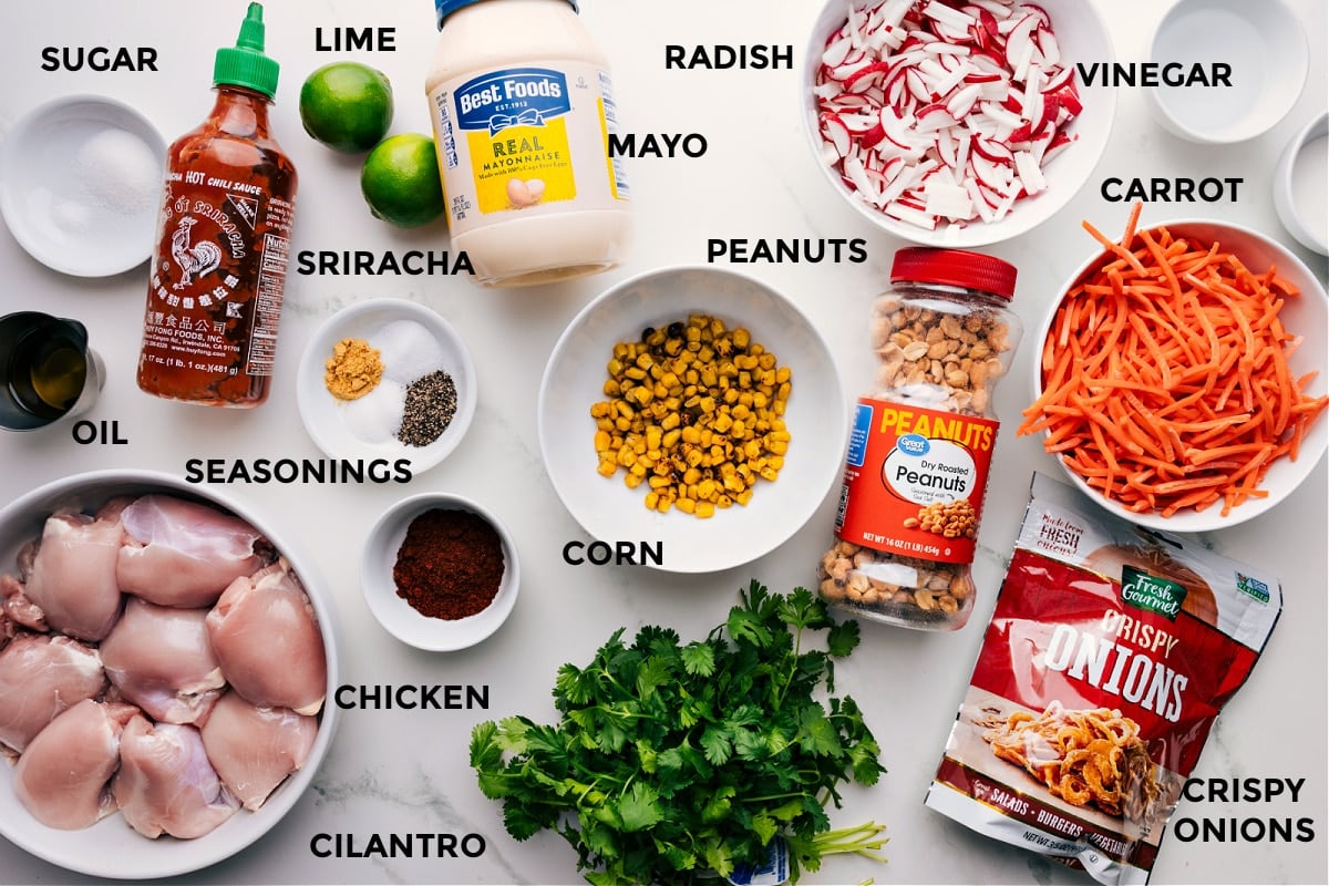 All ingredients prepped for easy assembly: sugar, sriracha, lime, mayo, radish, vinegar, carrot, peanuts, corn, seasonings, oil, meat, cilantro, and crispy onions.