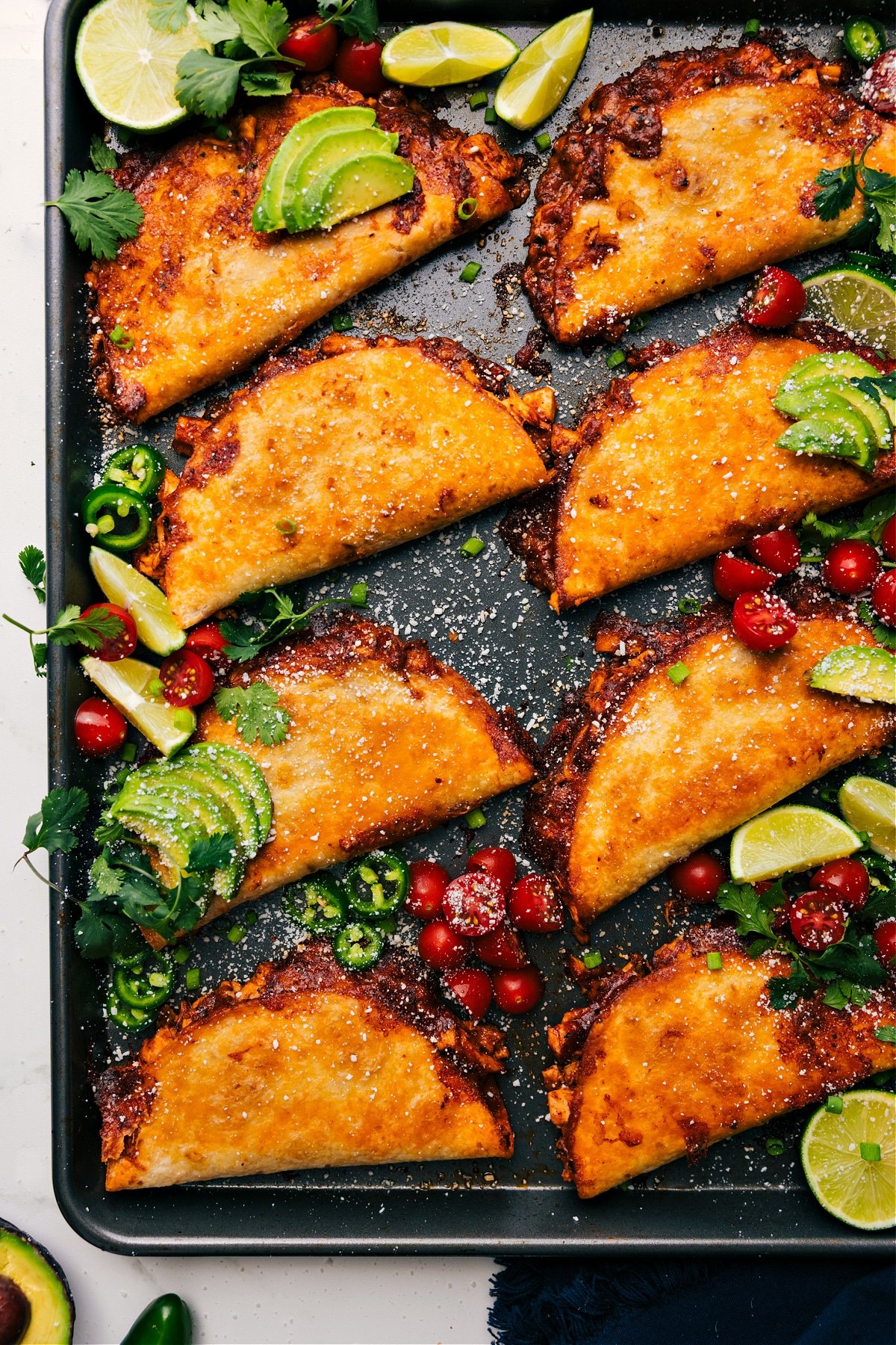 The Best Baked Chicken Tacos Recipe Baked Chicken Tacos on a sheet pan, topped with all the delicious toppings, ready to enjoy!