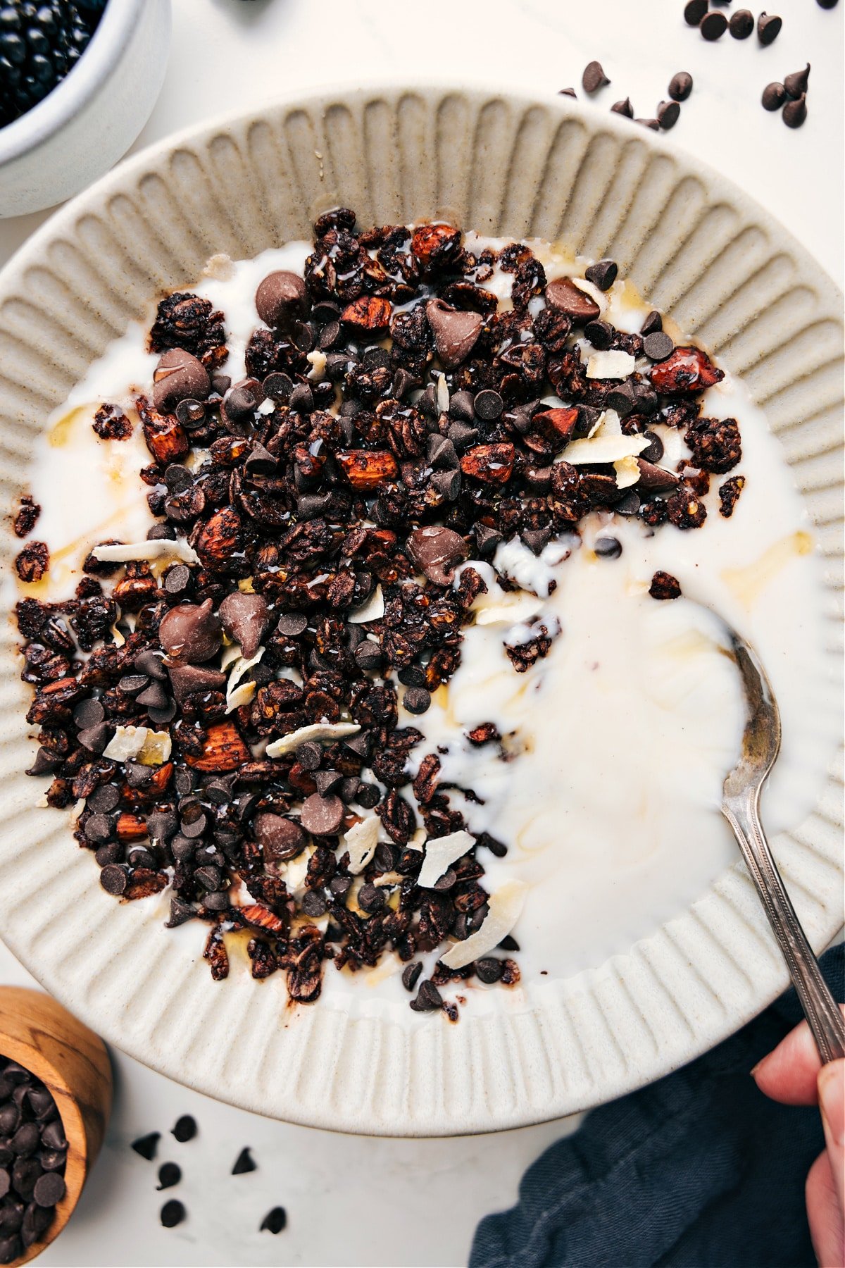 Chocolate Granola Is The Perfect On The Go Snack Chocolate granola served in a yogurt bowl with a drizzle of honey on top.
