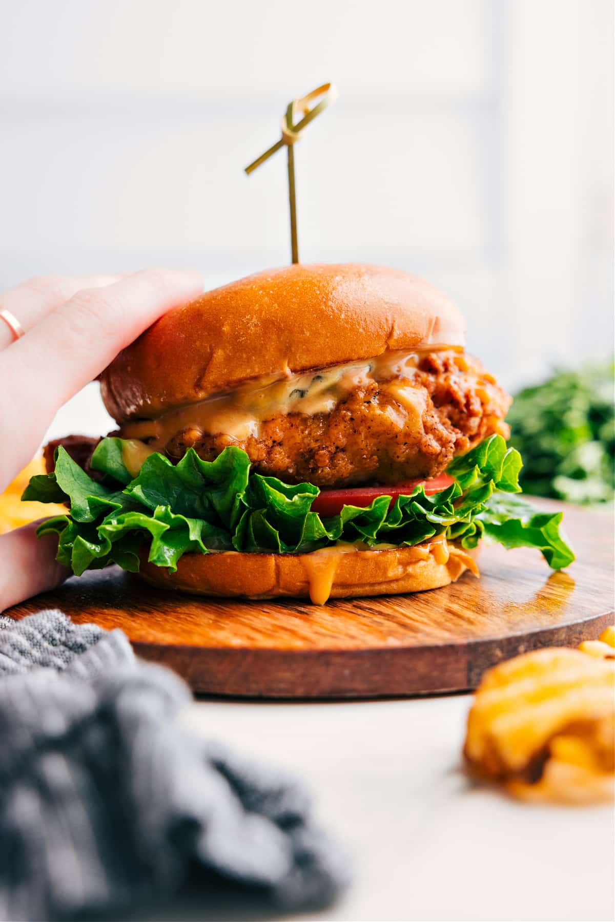 Crispy chicken sandwich on a toasted bun with lettuce, tomato, and a flavorful sauce.