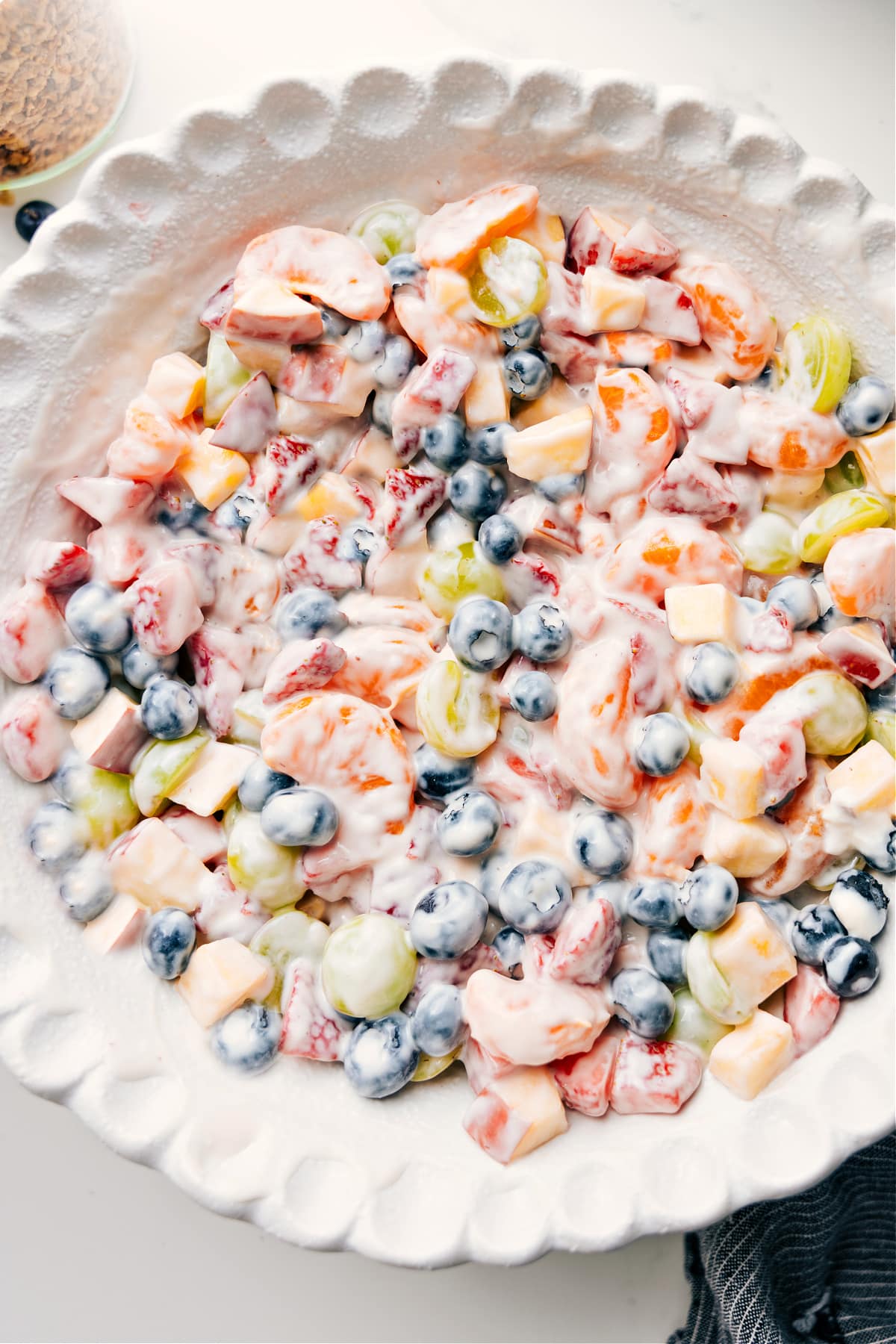 Fresh And Flavorful Fruit Salad With Yogurt Fruit salad with creamy yogurt dressing mixed in a bowl, ready to serve and enjoy.