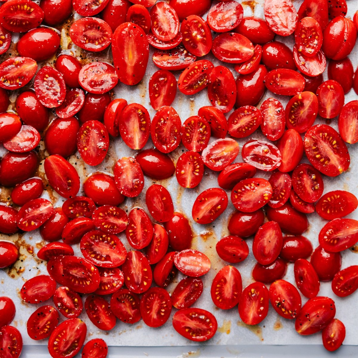 All the cherry tomatoes seasoned and coated in oil, ready to roast for the perfect roasted cherry tomatoes.