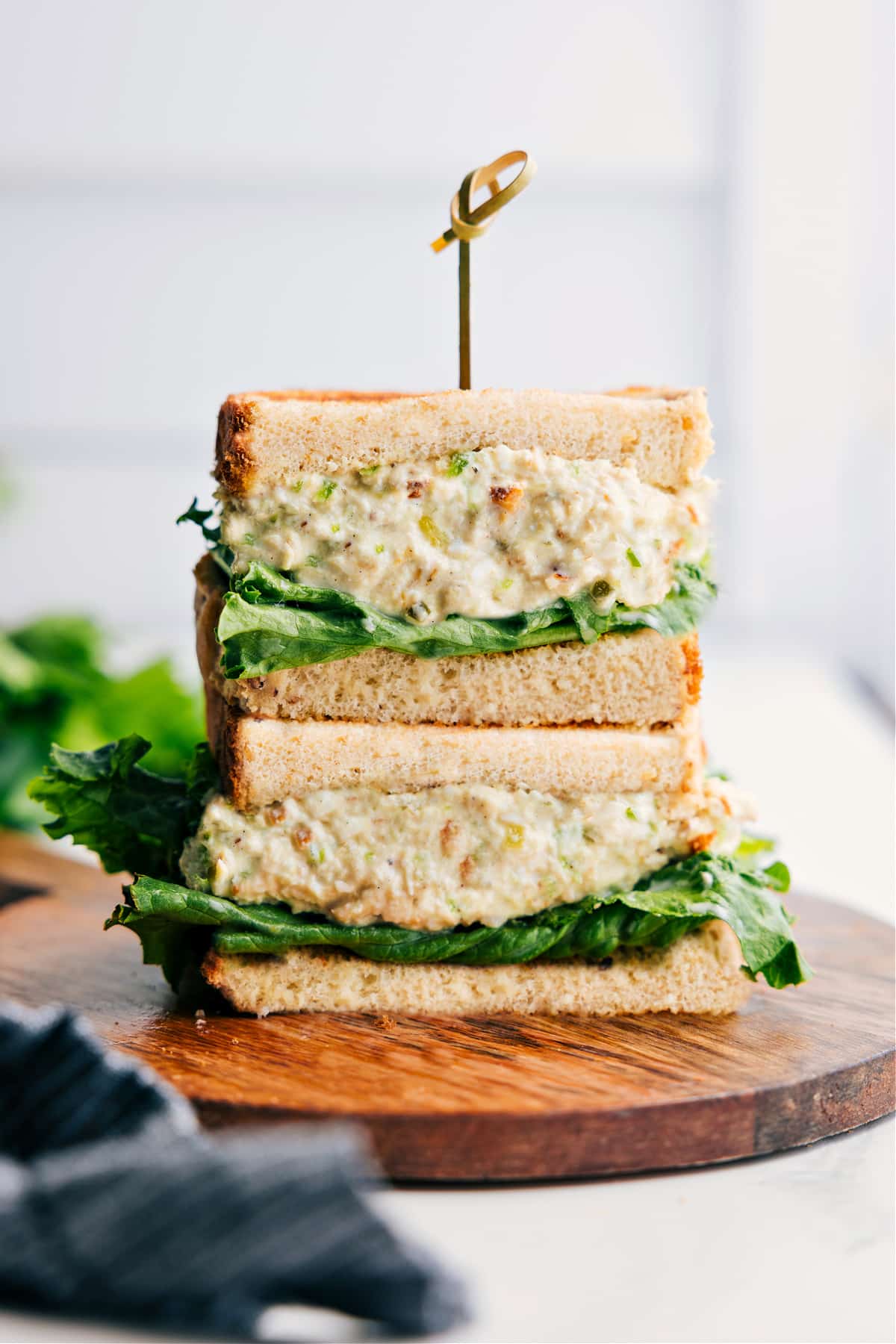 The Ultimate Copycat Chick-Fil-A Chicken Salad Recipe Chick-Fil-A Chicken Salad Recipe served in halved sandwich bread, stacked to show creamy chicken salad filling.