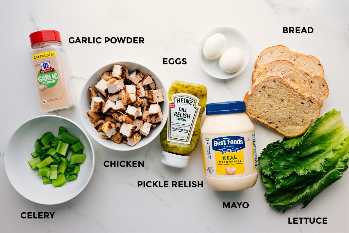 Ingredients In Chick-Fil-A Chicken Salad Recipe All ingredients for Chick-Fil-A Chicken Salad Recipe prepped and ready, including chicken, garlic powder, celery, relish, eggs, bread, and lettuce.