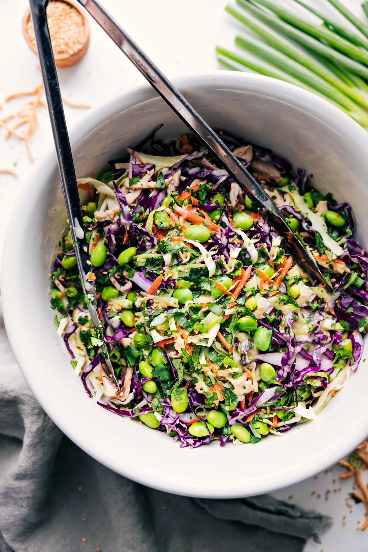 Asian Slaw Recipe in a bowl tossed together with dressing.