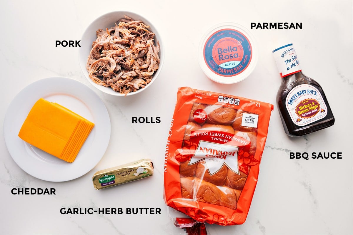 All the ingredients prepped for easy assembly: cheddar, garlic-herb butter, Hawaiian rolls, pork, Parmesan, and BBQ sauce.