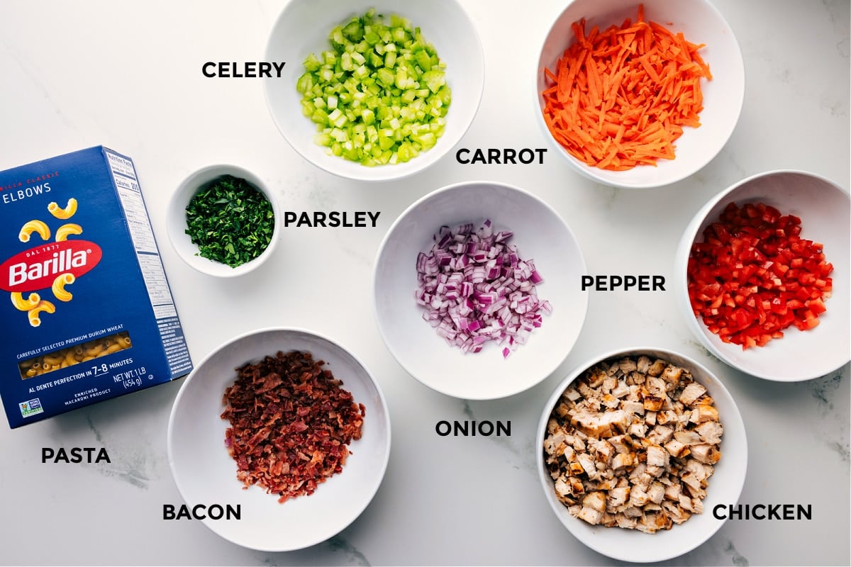 Ingredients in this recipe prepped out for easy assembly including the pasta, parsley, celery, carrot, onion, pepper, chicken, and bacon.