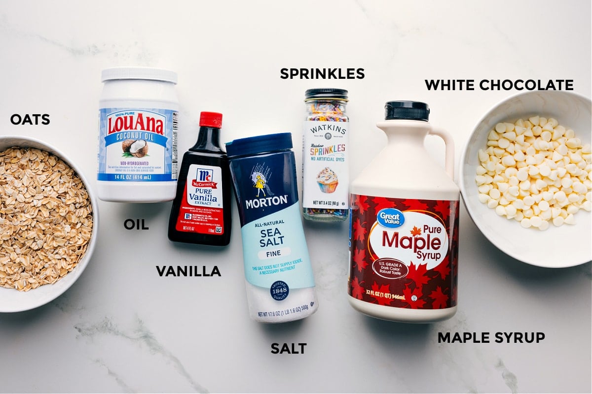 Ingredients in this recipe prepped out for easy assembly including the oats, oil, vanilla, salt, sprinkles, maple syrup, and white chocolate.