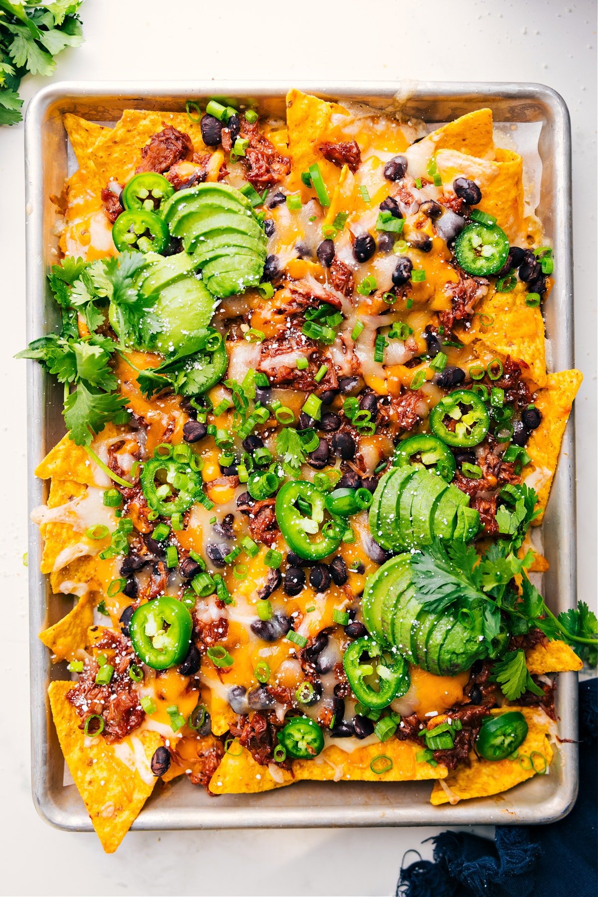 Pulled Pork Nachos Fresh Out Of Oven Freshly baked pulled pork nachos on a tray, hot and ready to eat.