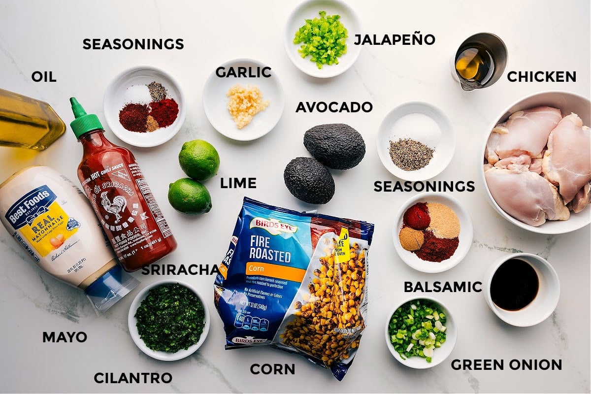 Ingredients in this recipe prepped out for easy assembly including the mayo, cilantro, seasonings, lime, garlic, jalapeno, balsamic, chicken, avocado, oil, green onions, and corn.