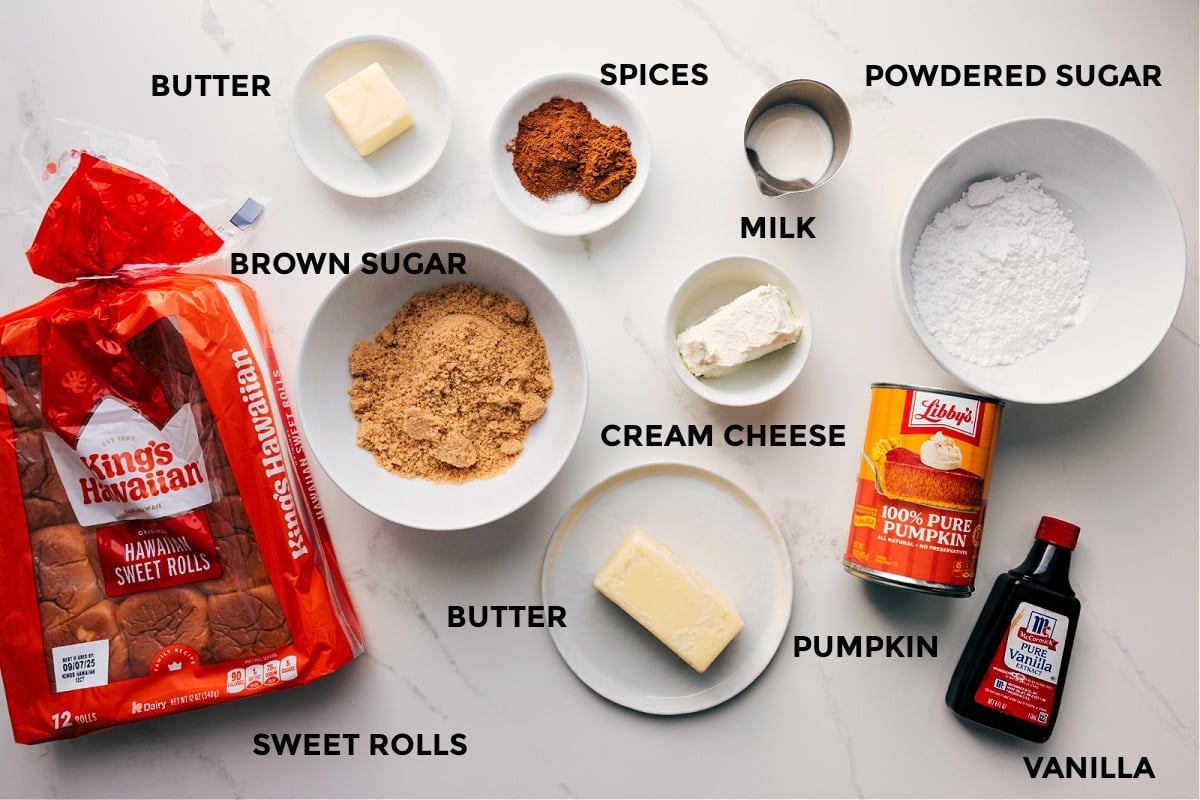 All the ingredients in this recipe prepped out for easy assembly: rolls, butter, brown sugar, spices, cream cheese, milk, powdered sugar, pumpkin, and vanilla.