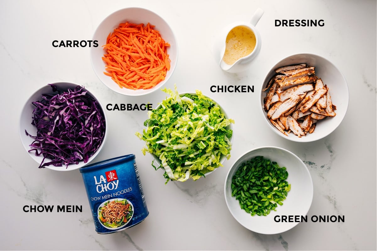 All the ingredients in this recipe prepped out for easy assembly including the cabbage, carrots, chow mein, chicken, dressing, and green onions.