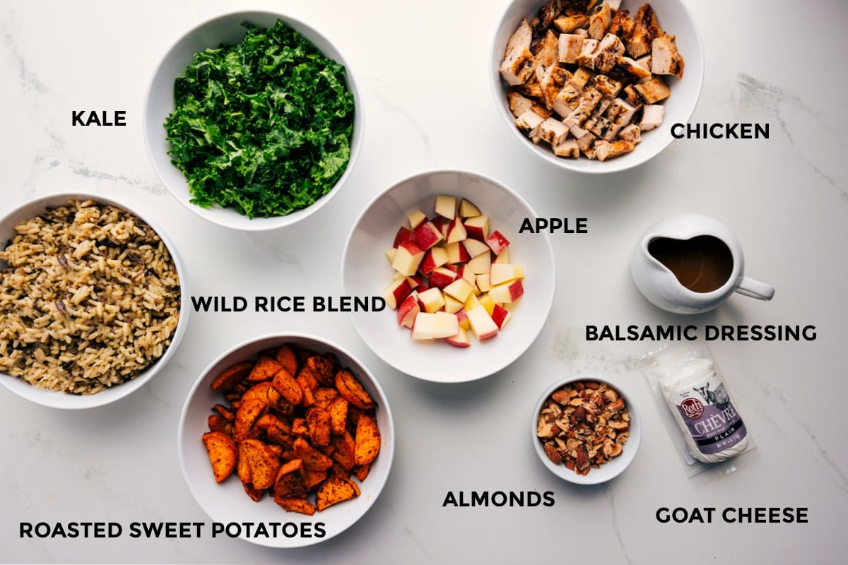 All the ingredients prepped out for easy assembly including the wild rice blend, kale, roasted sweet potatoes, apples, chicken, balsamic dressing, almonds, and goat cheese.