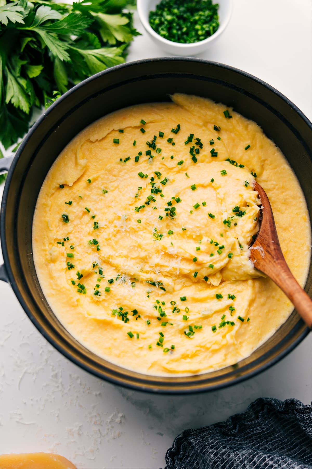 Cheesy Mashed Potatoes in the pot with fresh chives on top.