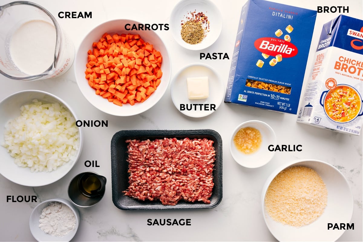 Ingredients In Creamy Parmesan Italian Sausage Soup All the ingredients for this recipe prepped and ready, including cream, veggies, flour, oil, sausage, pasta, butter, garlic, Parmesan, and broth.