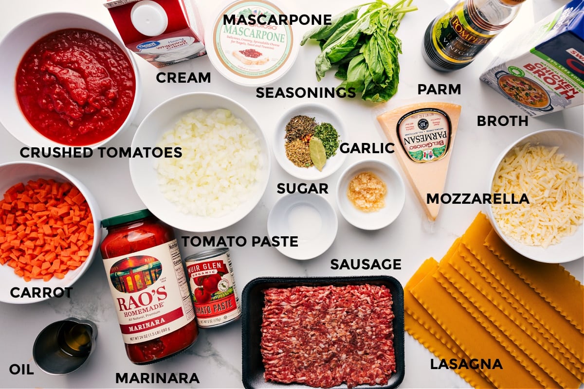 All the ingredients for this recipe prepped and ready, including tomatoes, veggies, marinara, tomato paste, sausage, seasonings, mascarpone, cream, Parmesan, mozzarella, lasagna noodles, broth, and fresh herbs.