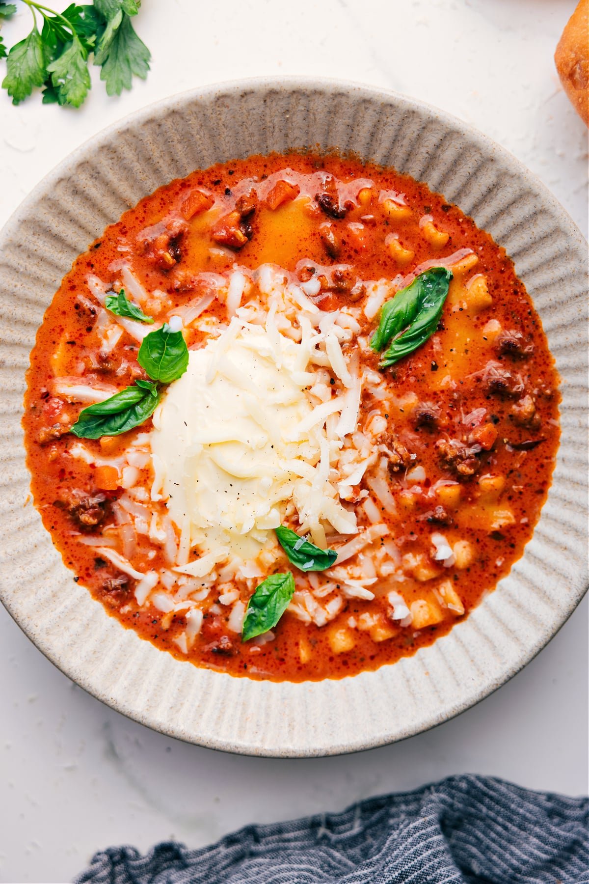 A bowl of the dish topped with freshly grated cheese and basil, ready to be enjoyed.