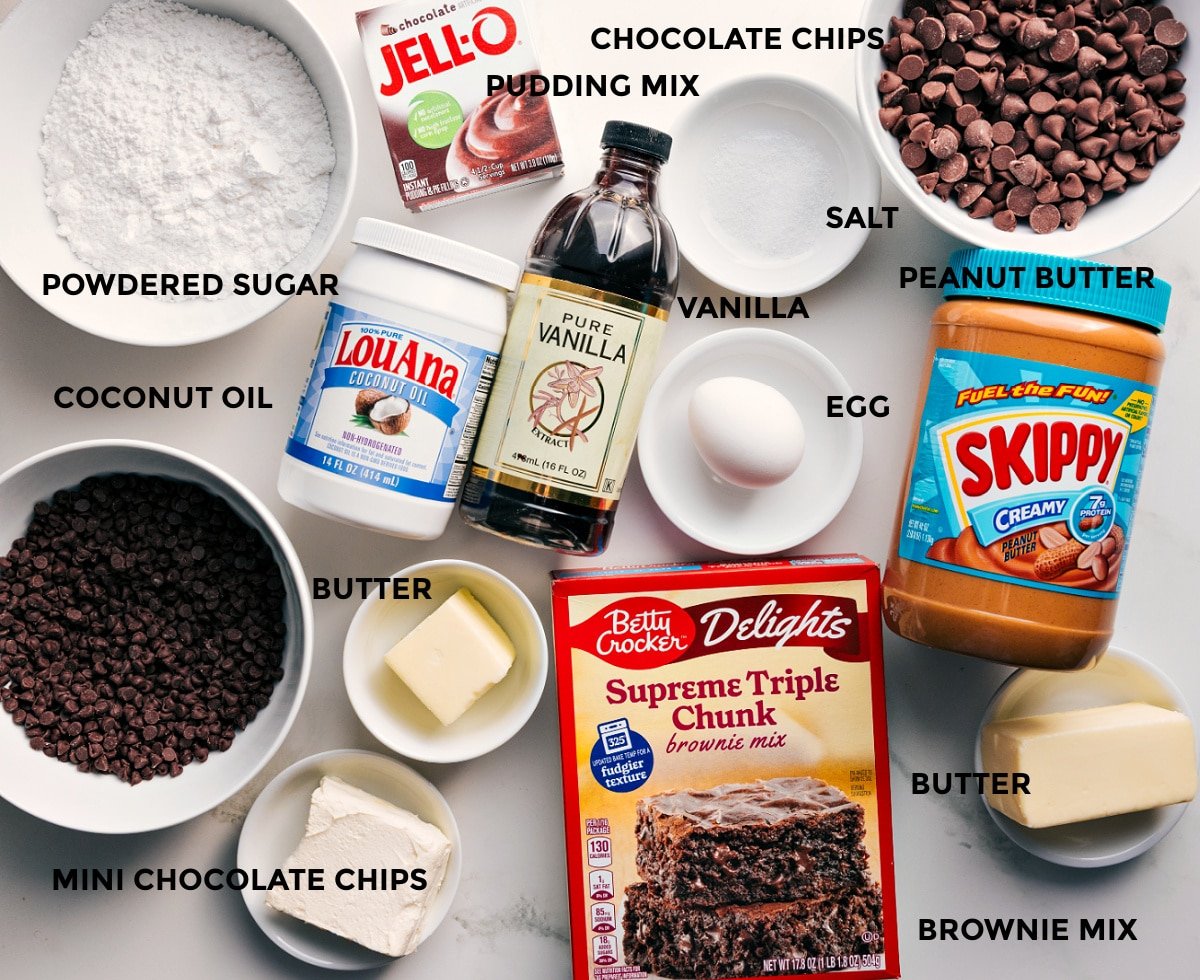 Ingredients In Buckeye Brownie Cookies All the ingredients in this recipe prepped out for easy assembly including the powdered sugar, coconut oil, chocolate chips, butter, vanilla, pudding mix, peanut butter, egg, and brownie mix.
