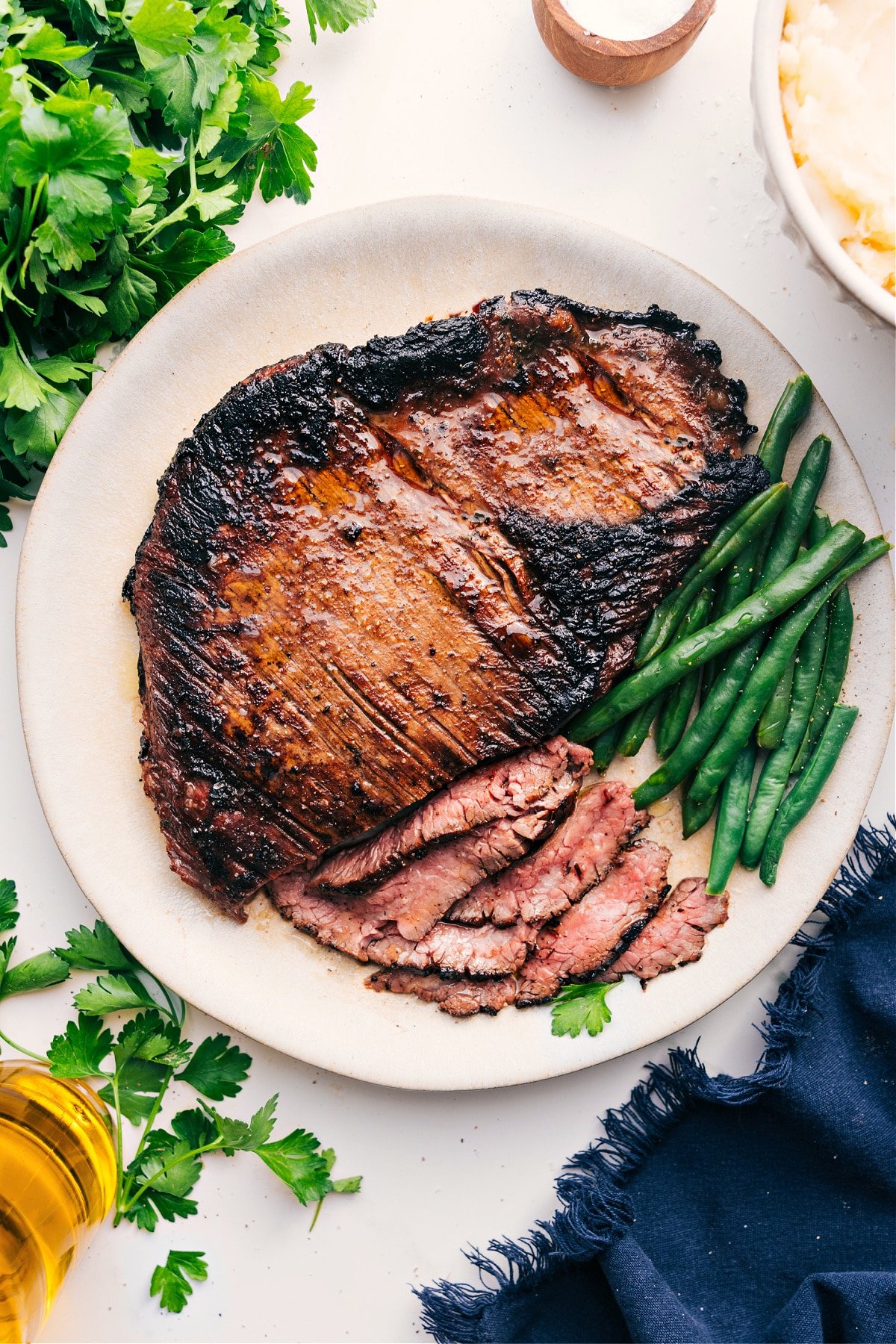 The Best London Broil Recipe London Broil Recipe partly sliced up on a plate ready to be enjoyed.