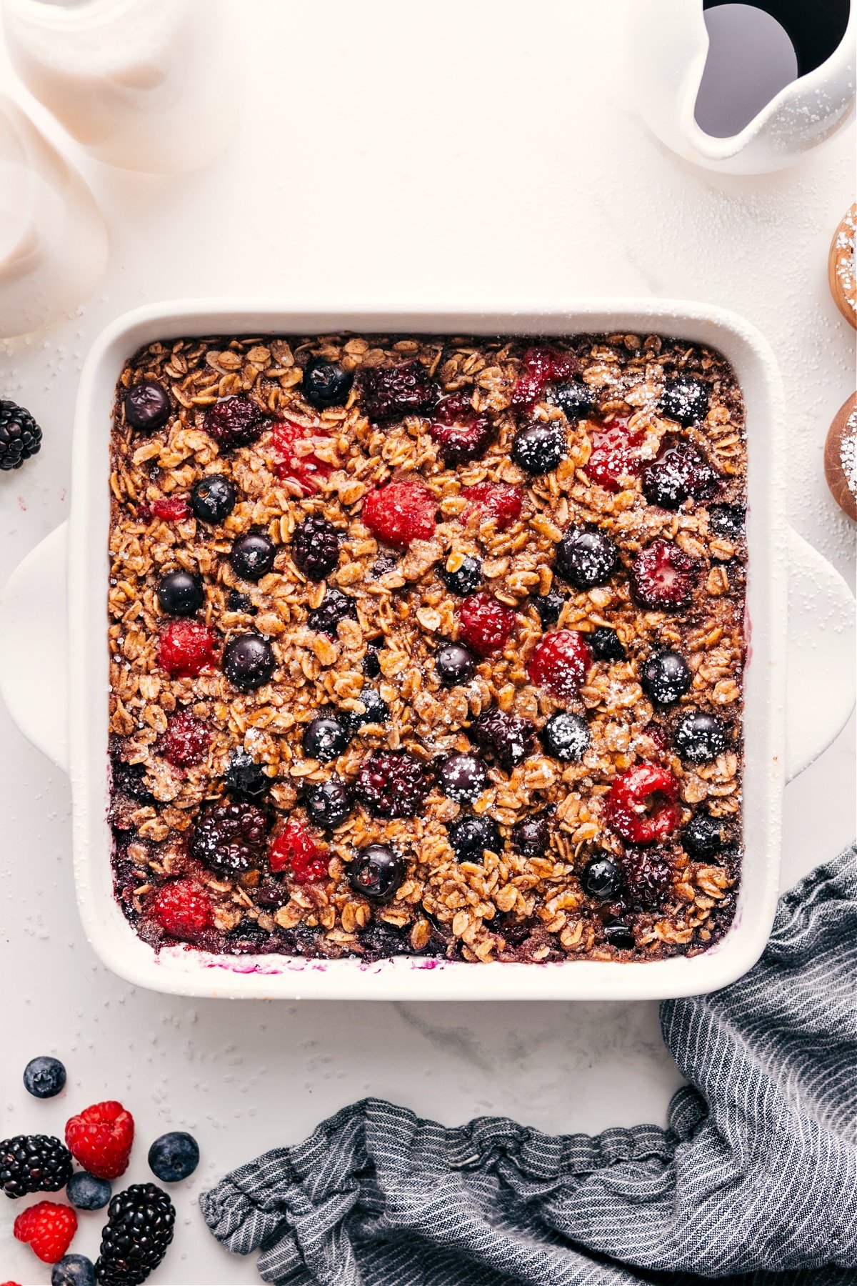 Berry Oatmeal Bake Is A Simple, Delicious Breakfast Staple Berry oatmeal bake in the pan with powdered sugar sprinkled on top.