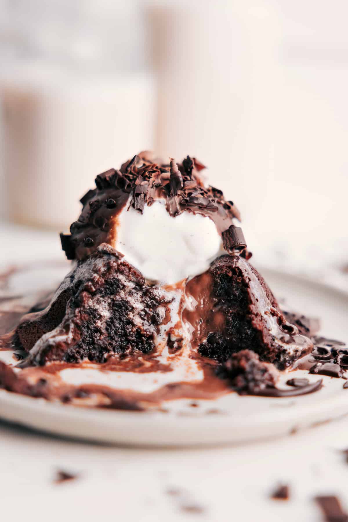 Chilis lava cake topped with vanilla ice cream and chocolate sauce, with a bite taken out showing the gooey chocolate center.
