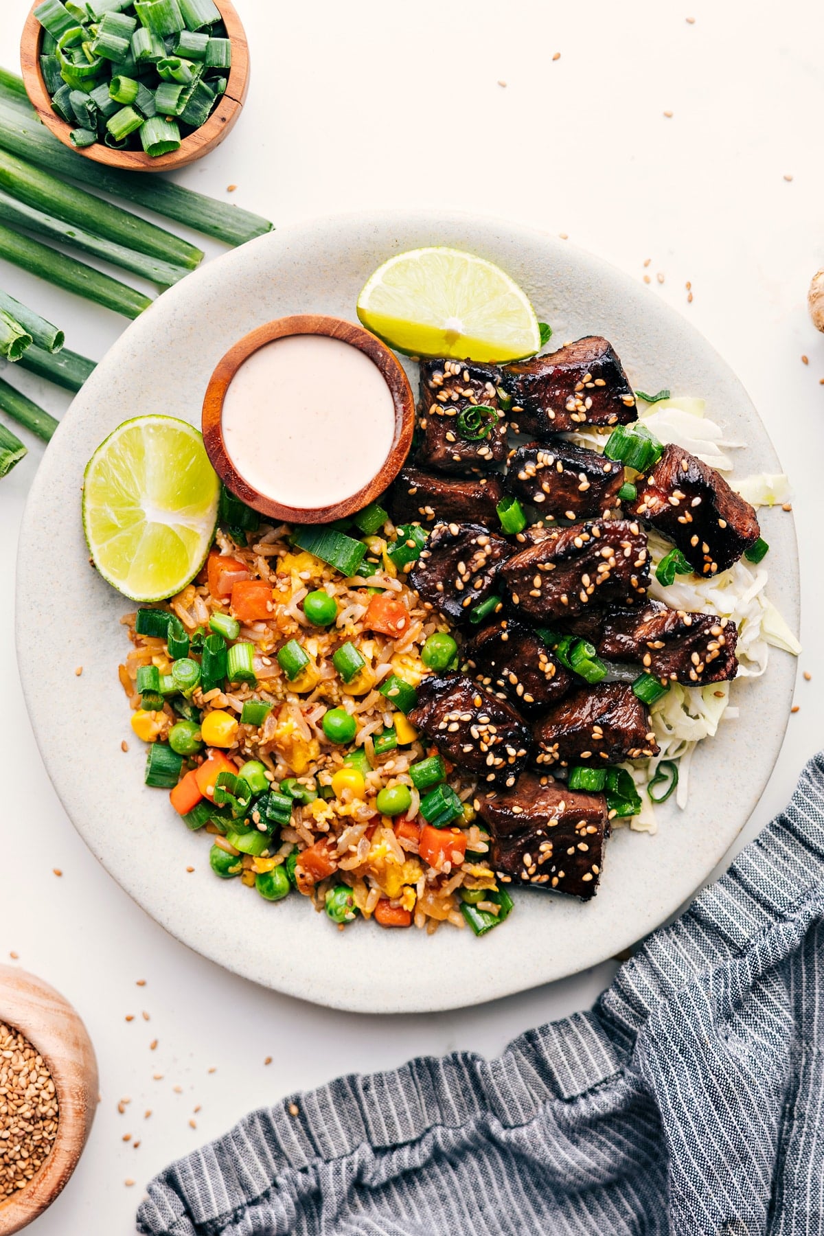 Make Hibachi At Home With These Hibachi Steak Bowls Hibachi steak bowl served over cabbage with fried rice and dipping sauce on the side.