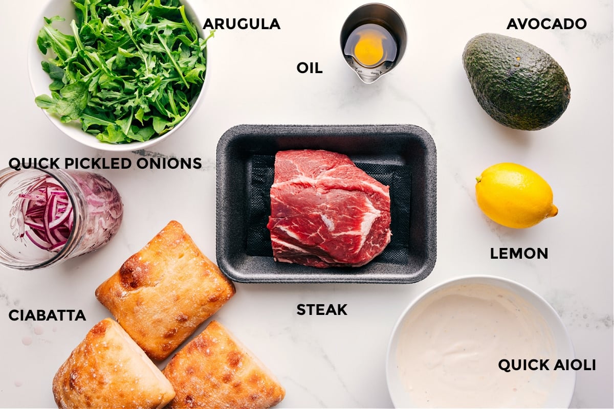 Ingredients In This Steak Sandwich Recipe All the ingredients in this recipe prepped out for easy assembly including the arugula, pickled red onions, ciabatta, steak, oil, avocado, lemon, and a quick aioli.