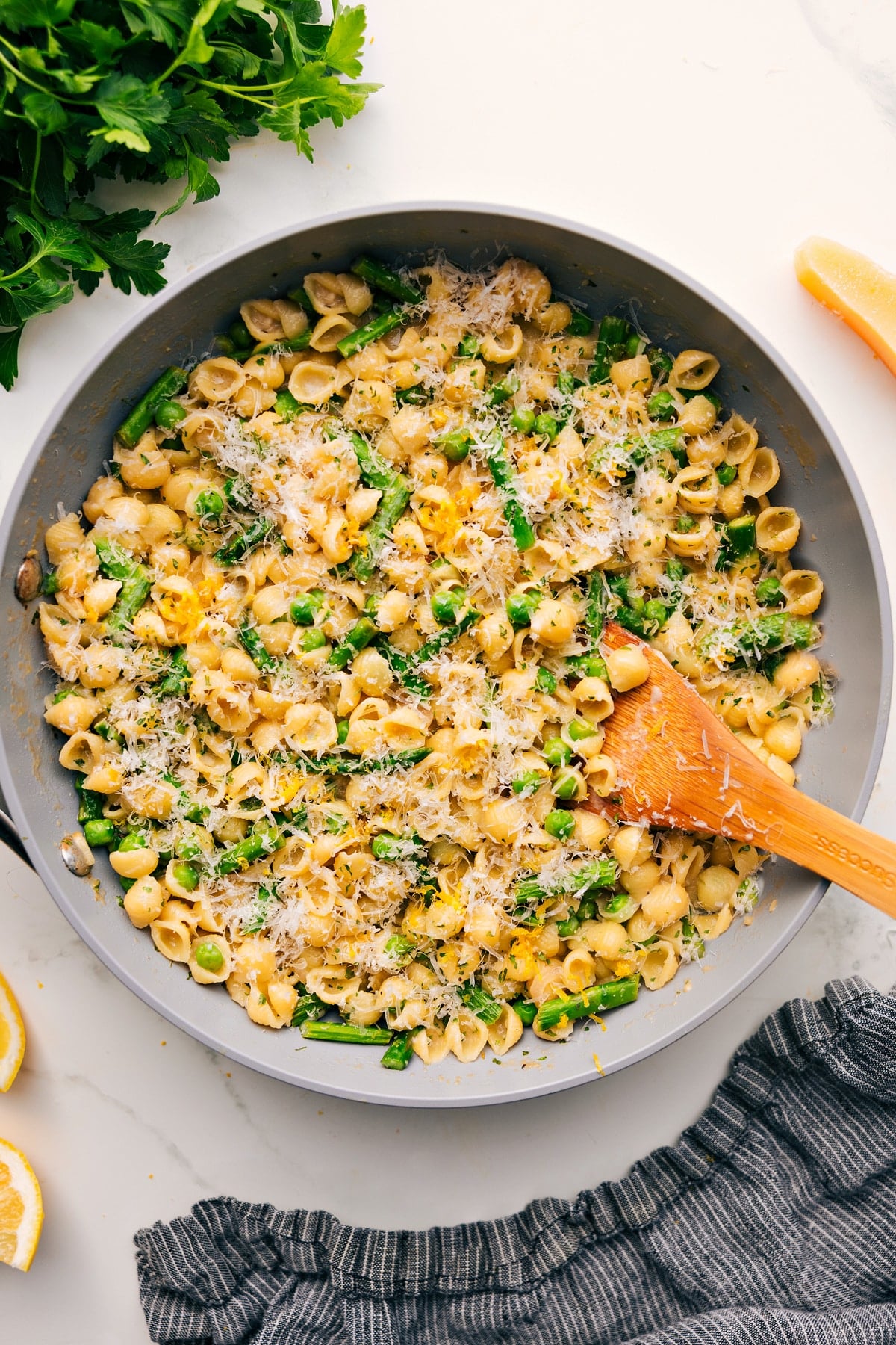 One Pot Asparagus Pasta Recipe Asparagus pasta recipe in a pot topped with freshly grated Parmesan cheese, with a spoon ready to serve.