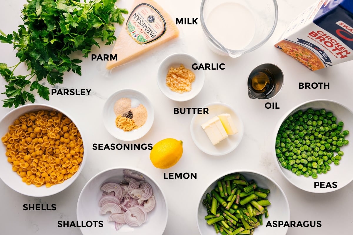 Ingredients In This Asparagus Pasta Recipe All the ingredients in this recipe prepped out for easy assembly including the parsley, shells, shallots, asparagus, peas, lemon, seasonings, butter, garlic, oil, broth, milk, and parmesan.