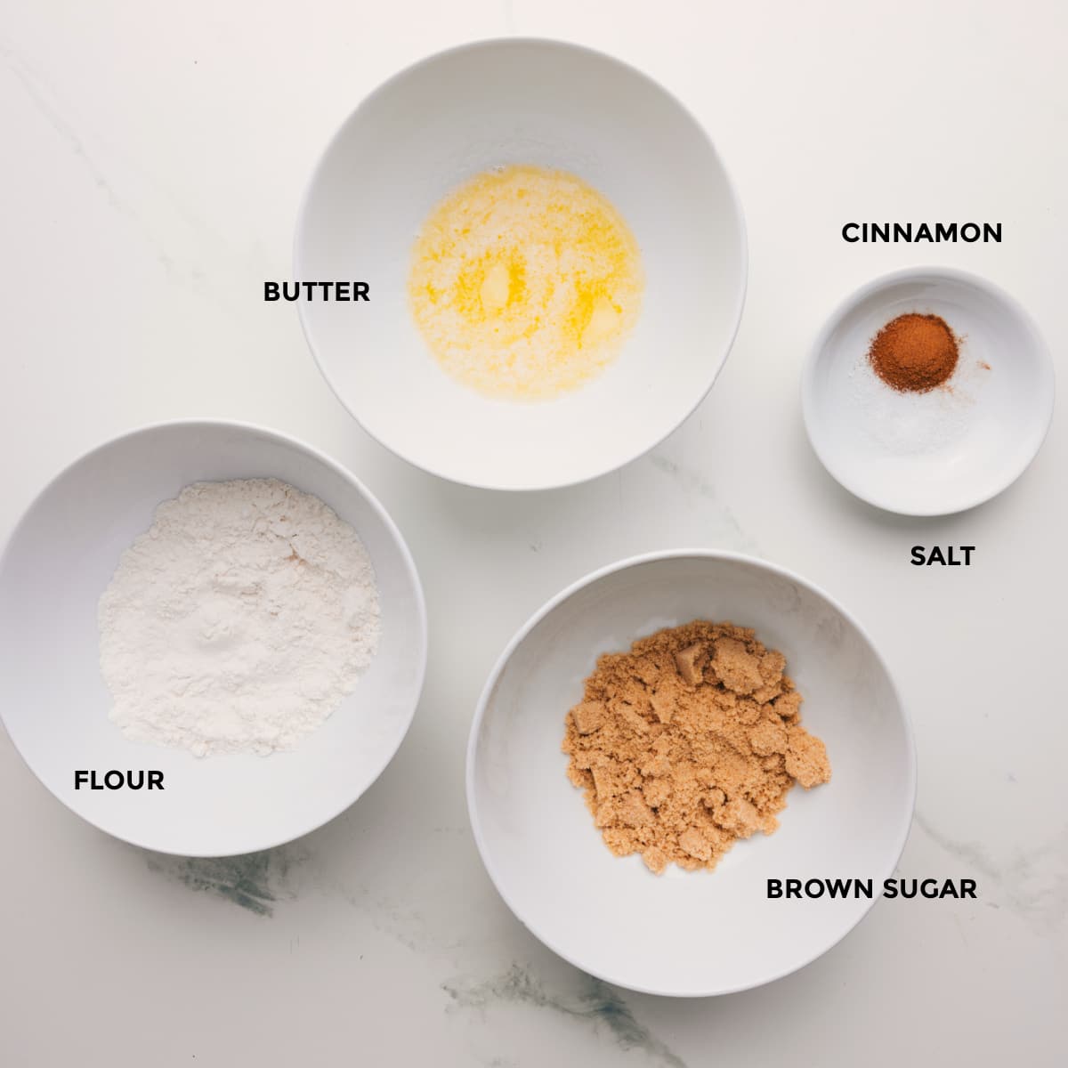 Ingredients In Crumb Topping The crumb topping prepped into bowls for easy assembly including flour, butter, brown sugar, and cinnamon.