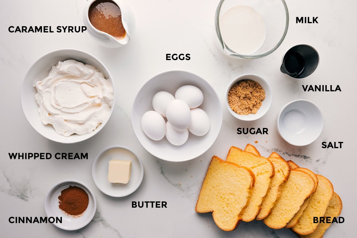All the ingredients in this recipe prepped out for easy assembly including the whipped cream, cinnamon, butter, bread, eggs, sugar, salt, vanilla, milk, and syrup.