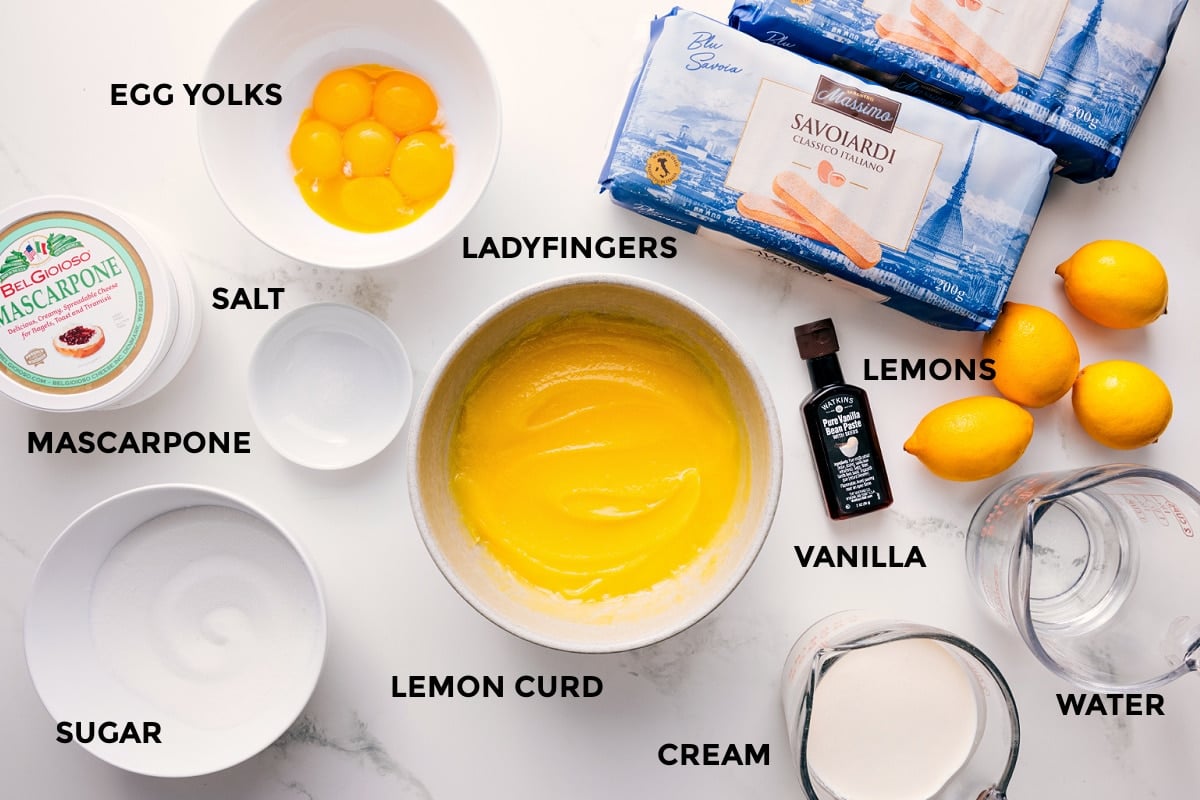 Lemon Tiramisu Ingredients All the ingredients in this recipe prepped out for easy assembly including the egg yolks, salt, mascarpone, sugar, lemon curd, cream, water, lemons, vanilla, and ladyfingers.