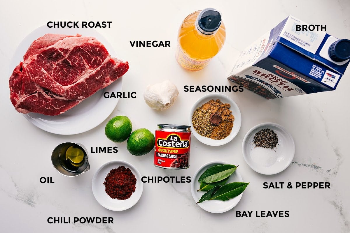 Ingredients In Barbacoa Beef Recipe All the ingredients in this recipe prepped out for easy assembly including the chuck roast, oil, seasonings, limes, chipotles, bay leaves, broth, and vinegar.