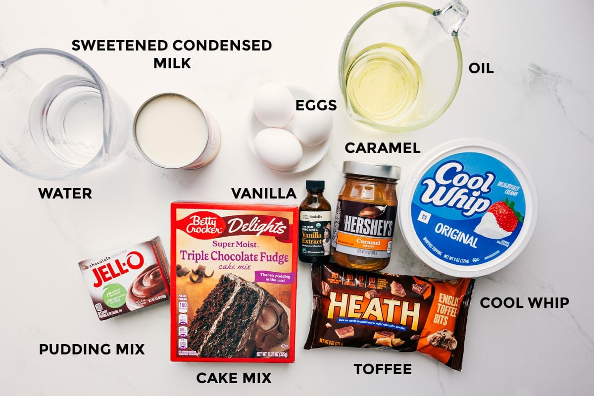Ingredients In This Chocolate Poke Cake All the ingredients in this recipe prepped out for easy assembly including the sweetened condensed milk, water, pudding mix, cake mix, toffee, cool whip, caramel, vanilla, oil, and eggs.