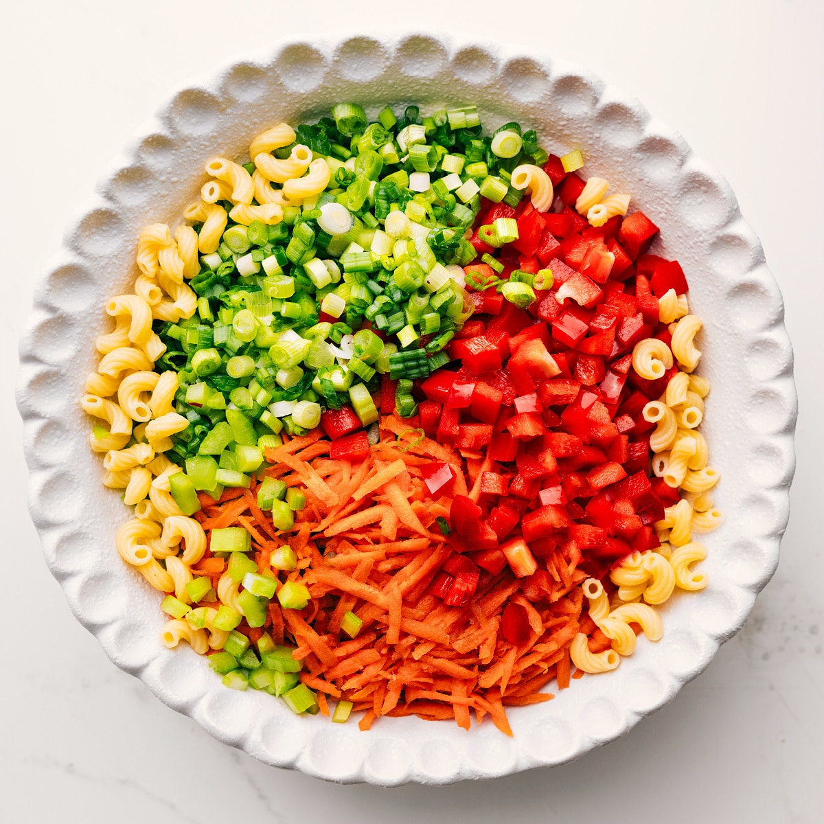 How To Make This Macaroni Salad Recipe All the ingredients added to a large bowl not mixed together yet.