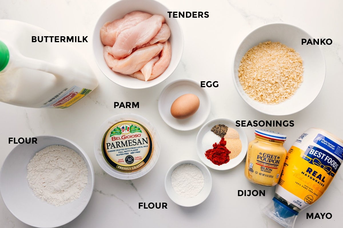 Ingredients In Parmesan Chicken Tenders All the ingredients in this recipe prepped out for easy assembly including the buttermilk, meat, parm, flour, seasonings, egg, dijon, mayo, and panko.